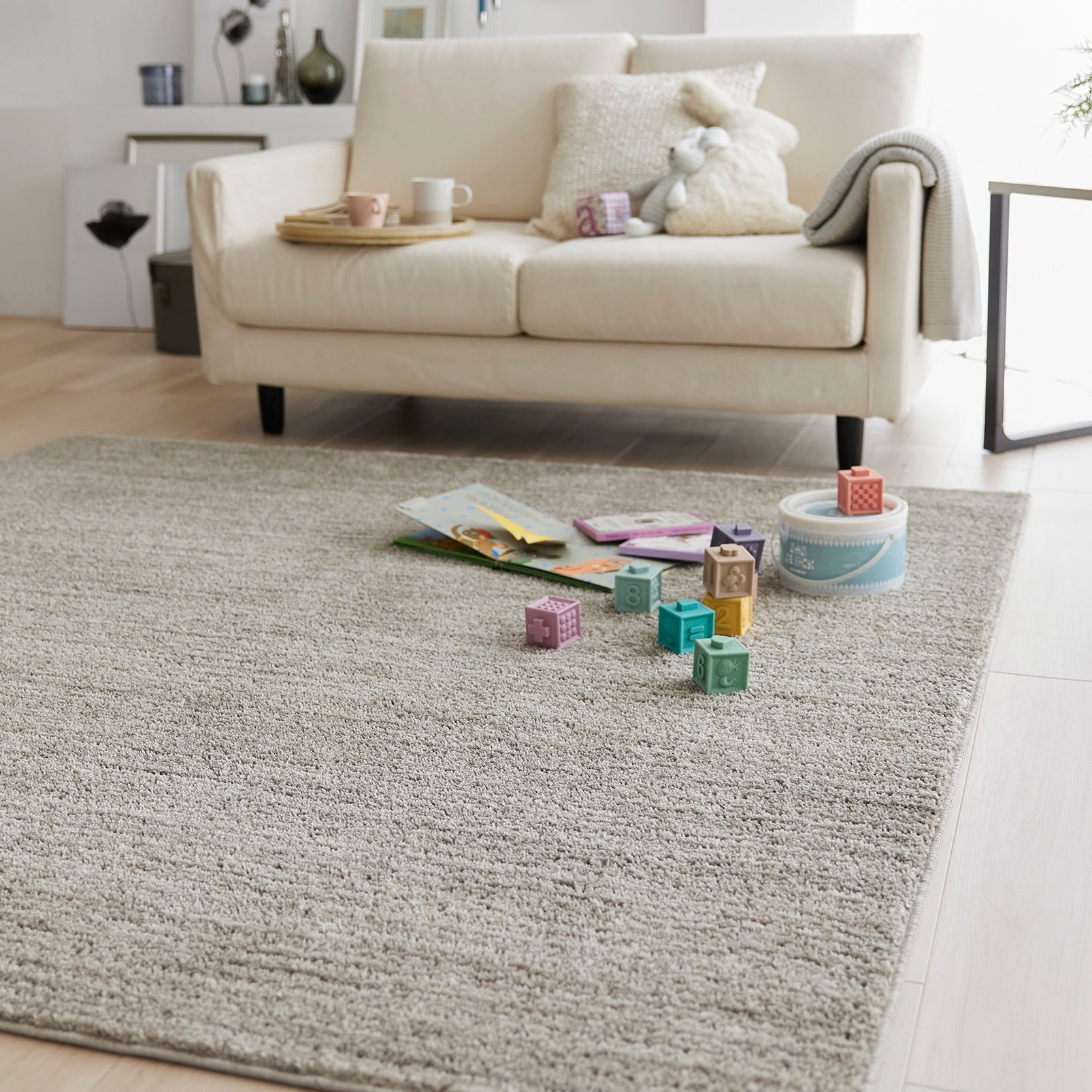 グレージュのナチュラルラグの上にブロックのおもちゃが置いてある様子