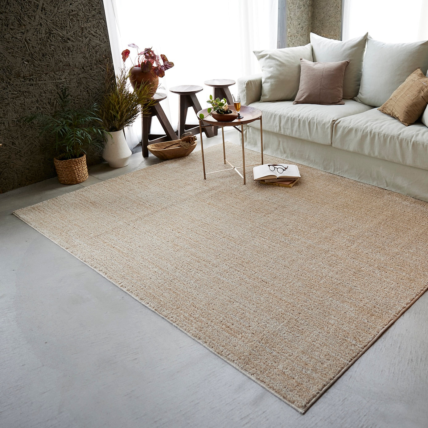 ベージュのナチュラルラグをソファ前に敷いている様子