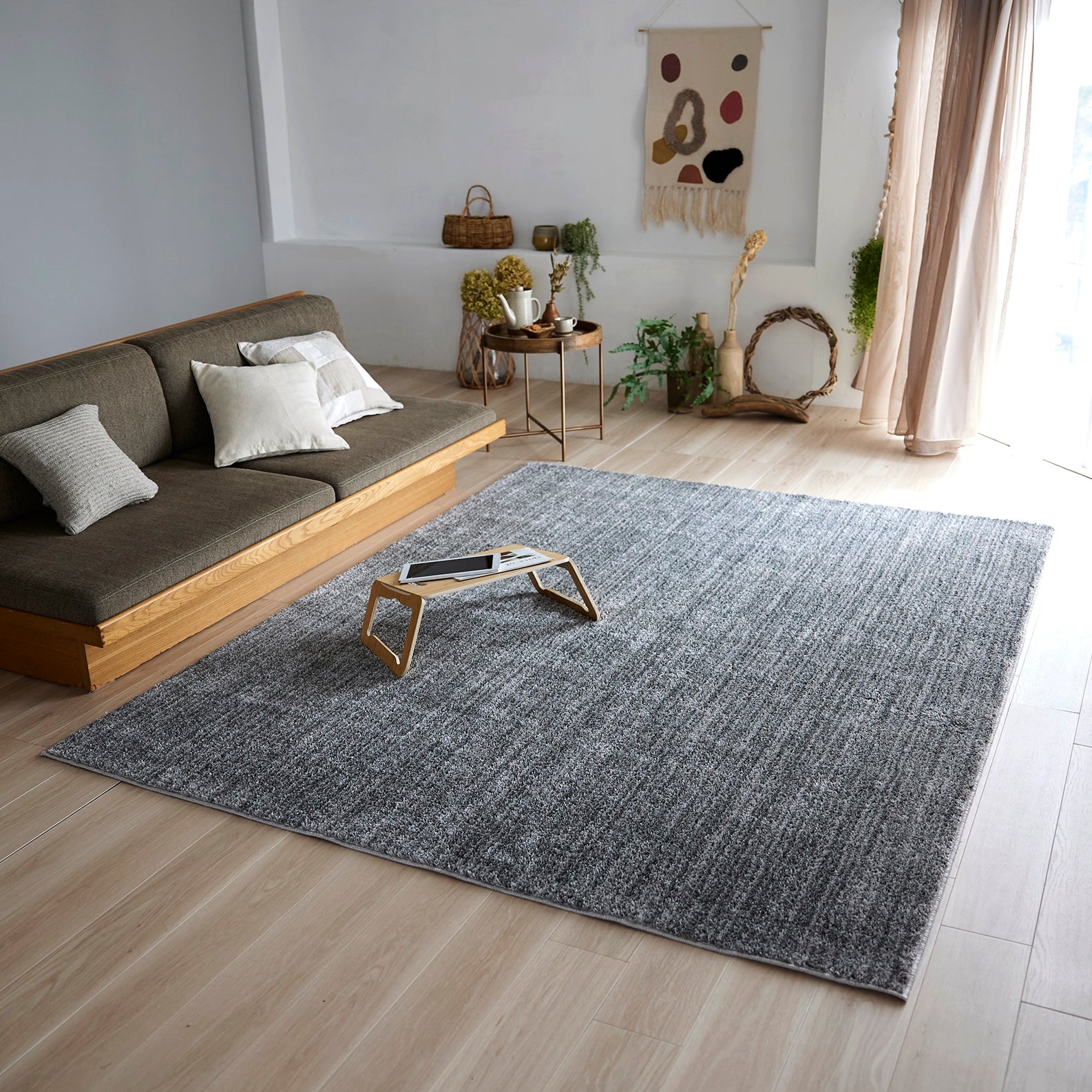 グレーのナチュラルラグを部屋に敷いている様子