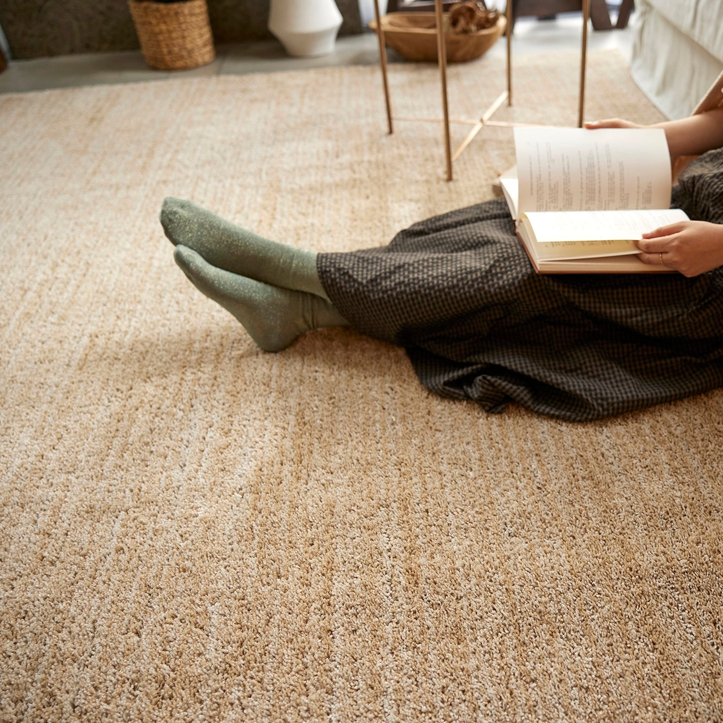 ベージュのナチュラルラグの上に腰掛けている様子