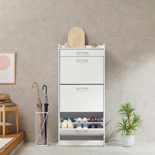 ホワイトのフラップ扉式シューズケースを玄関に置いている様子