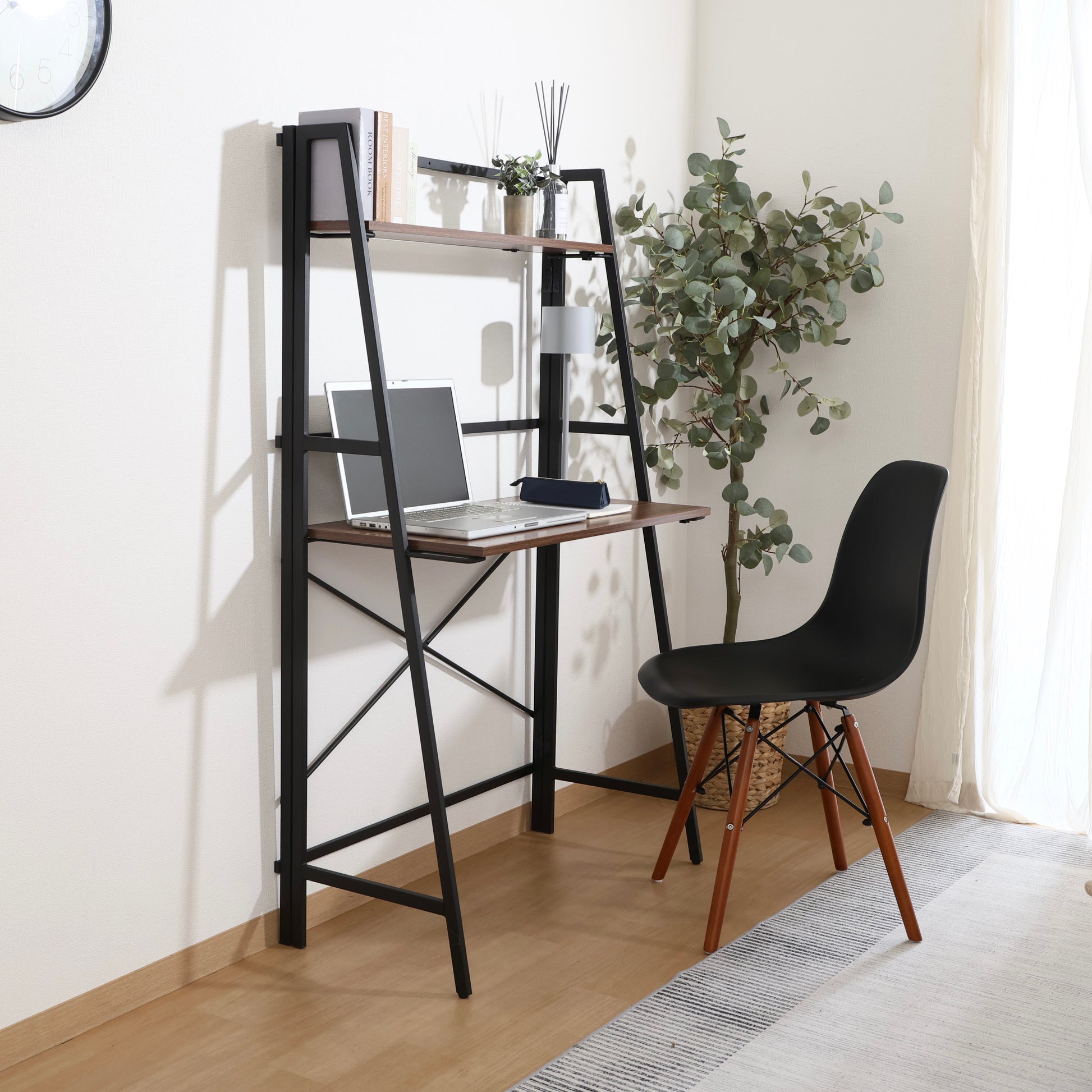 収納棚が付いた折りたたみ式のデスクにパソコンや本が置かれている様子