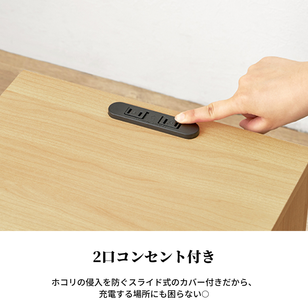 黒いプラスチック製のスライド式コンセントカバーが木製のコンパクトナイトテーブルに埋め込まれている。