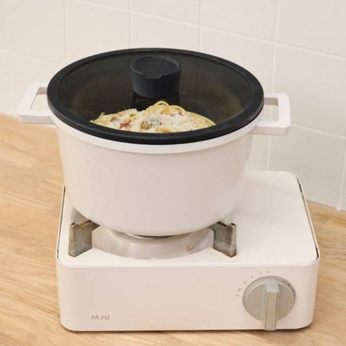 蓋付きの両手鍋がコンロの上に置かれている