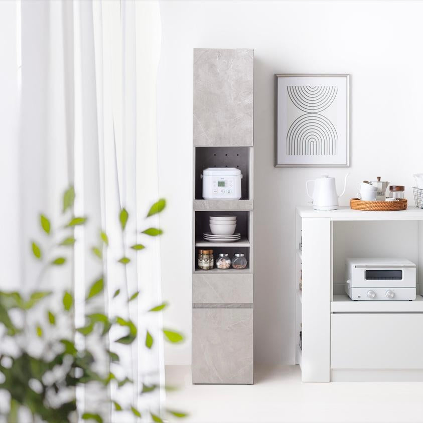 グレーの隙間キッチンボードに家電やお皿が収納されている