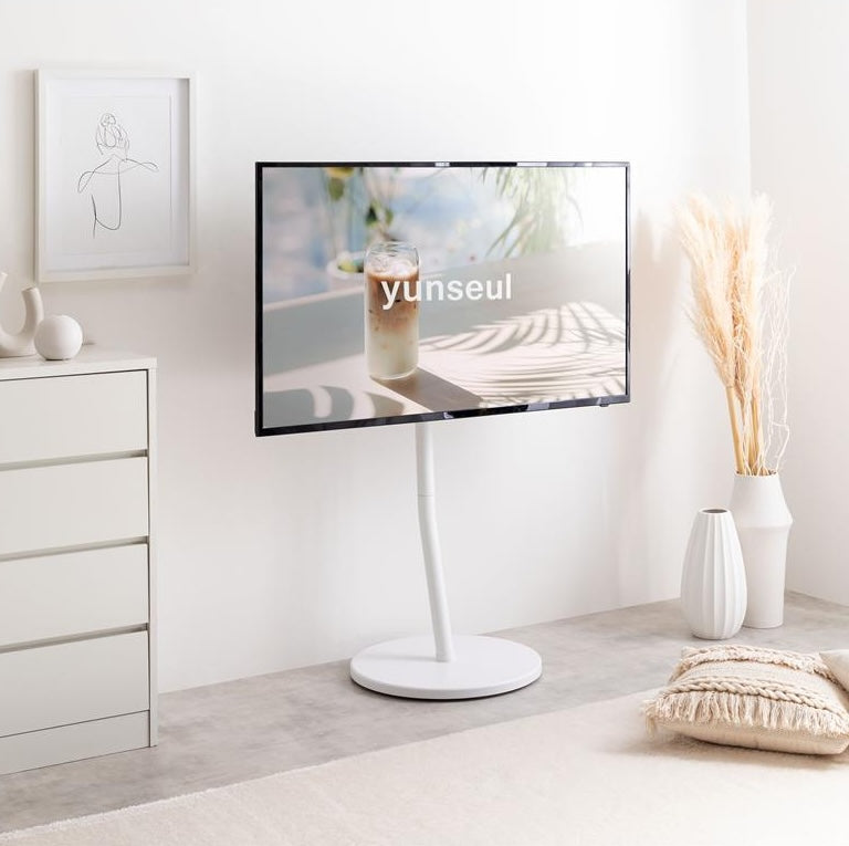 ホワイトのキャスター付きテレビスタンドを部屋に置いている様子