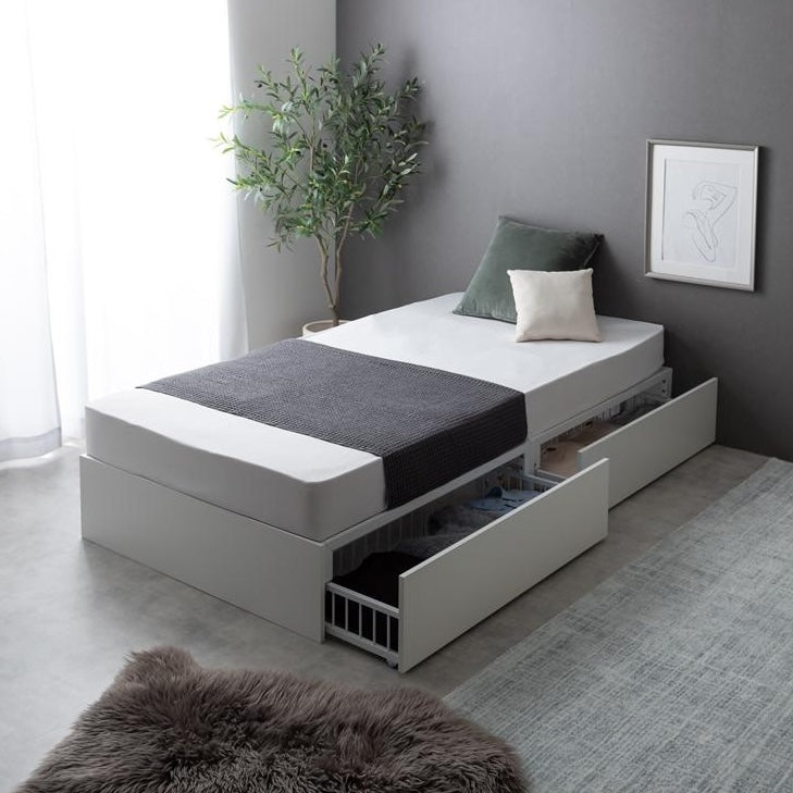 シンプルな白のベッドフレームに2杯の引き出しが付いていて、シックな雰囲気の部屋で使っている