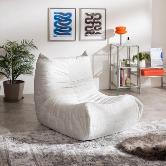 曲線フォルムと低重心デザインがお洒落な白い1人掛けソファが部屋に置いてあるインテリア