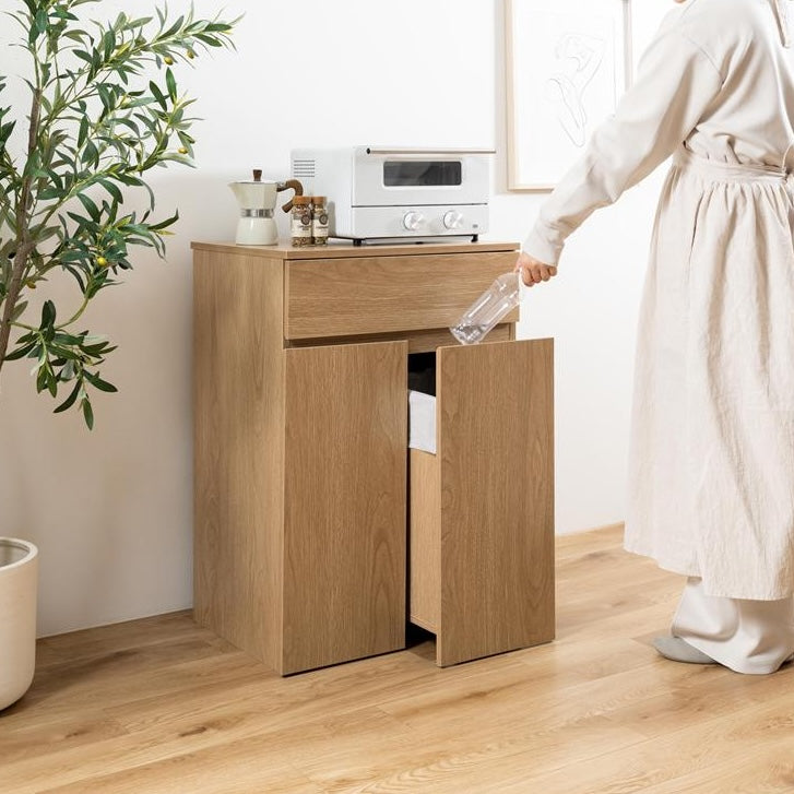 木目がナチュラルなカラーのゴミ箱とキッチンボードが一体となった収納家具を置いているキッチン