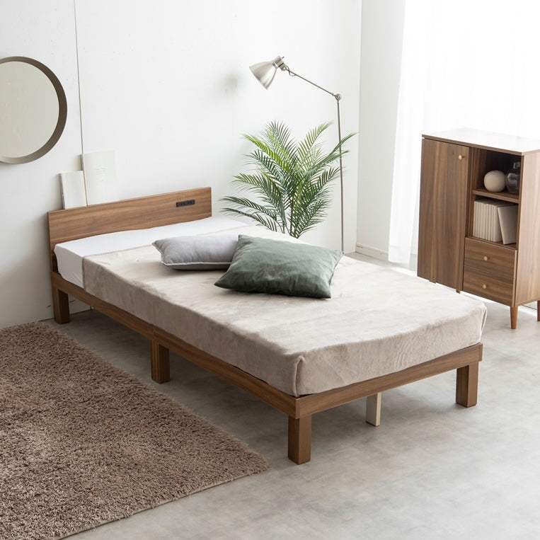 天然木製のブラウンのヘッドボードに2口コンセントが付いたシンプルなベッドフレームを部屋で使っている