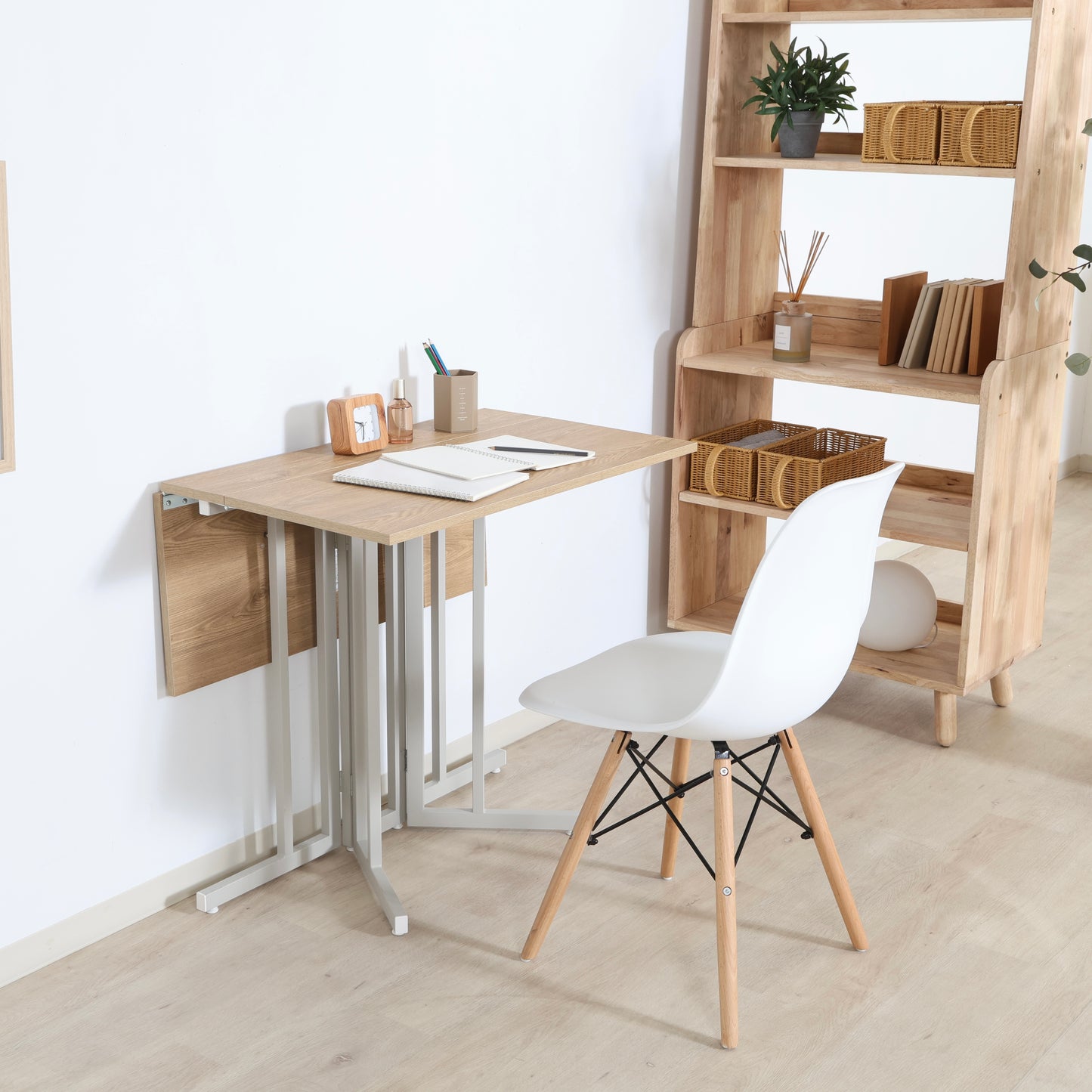 ウッド天板とスチール脚の異素材組み合わせの折りたたみ式のテーブルが壁寄せで置かれている様子