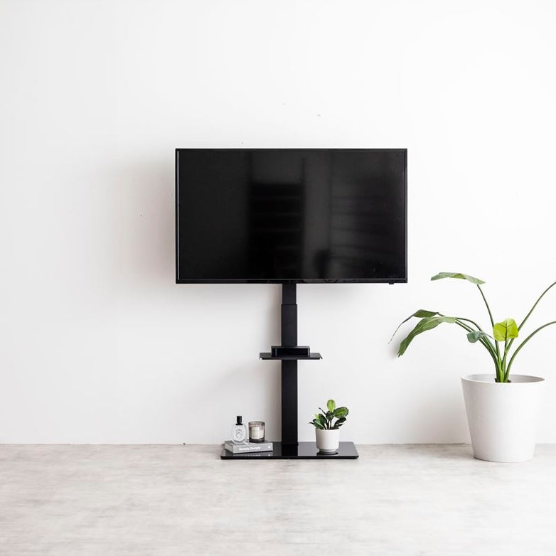 ラック付きのブラックのテレビスタンドが壁に寄せられている様子