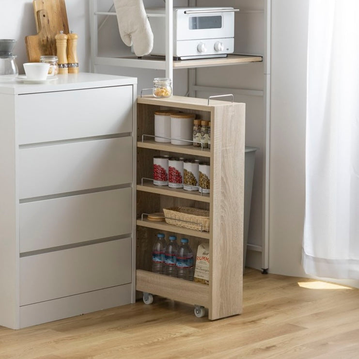 隙間に収まるナチュラルウッドカラーの収納ワゴンをキッチンで使い、食品や水のストックを保管している