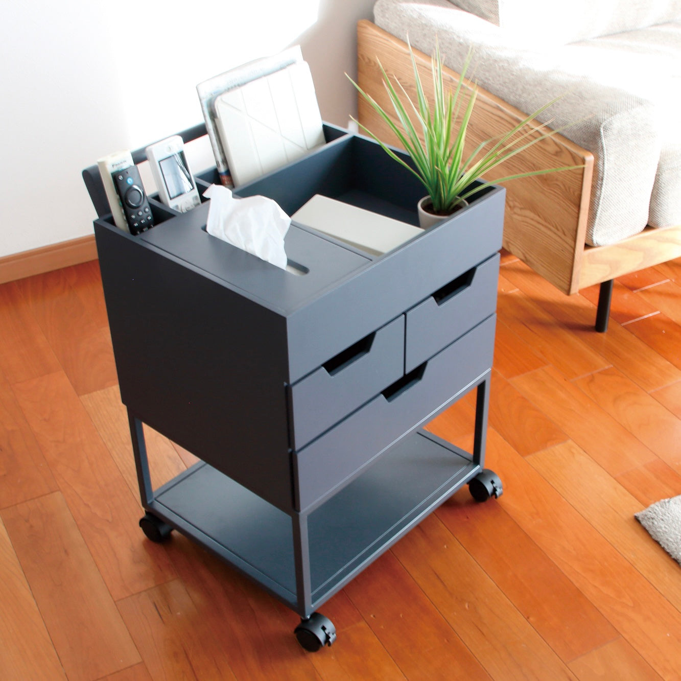 引き出しがたくさんついたネイビーのワゴンにティッシュや小物が収納されている様子