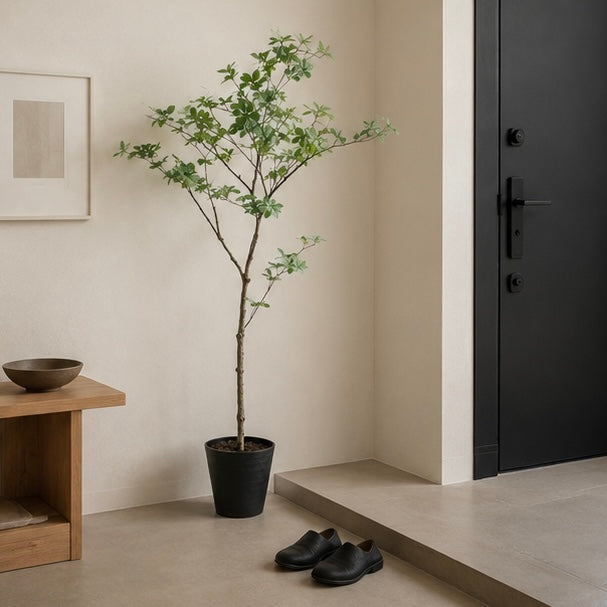 Tall green leafy fake dodan tsutsuji plant in a sleek black pot for indoor decoration