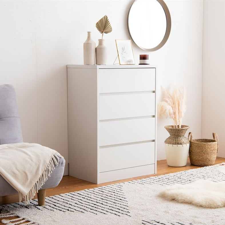 白の引き出しが4段のチェストを部屋の中でソファの横に置いている