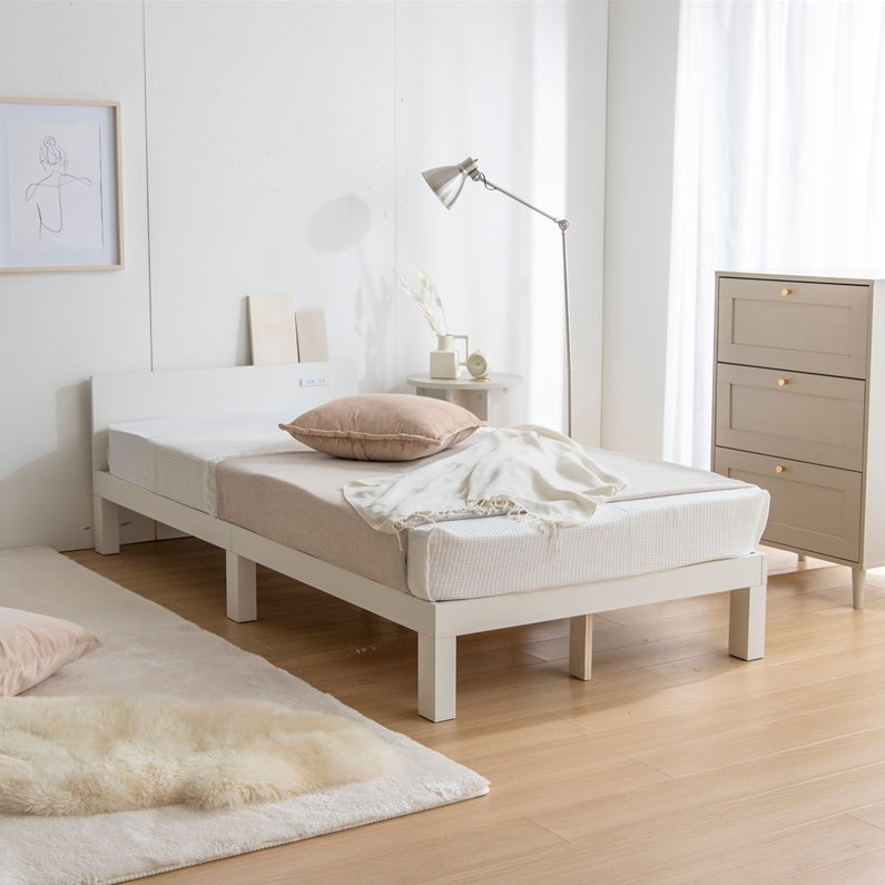 天然木製の白のヘッドボードに2口コンセントが付いたシンプルなベッドフレームを部屋で使っている