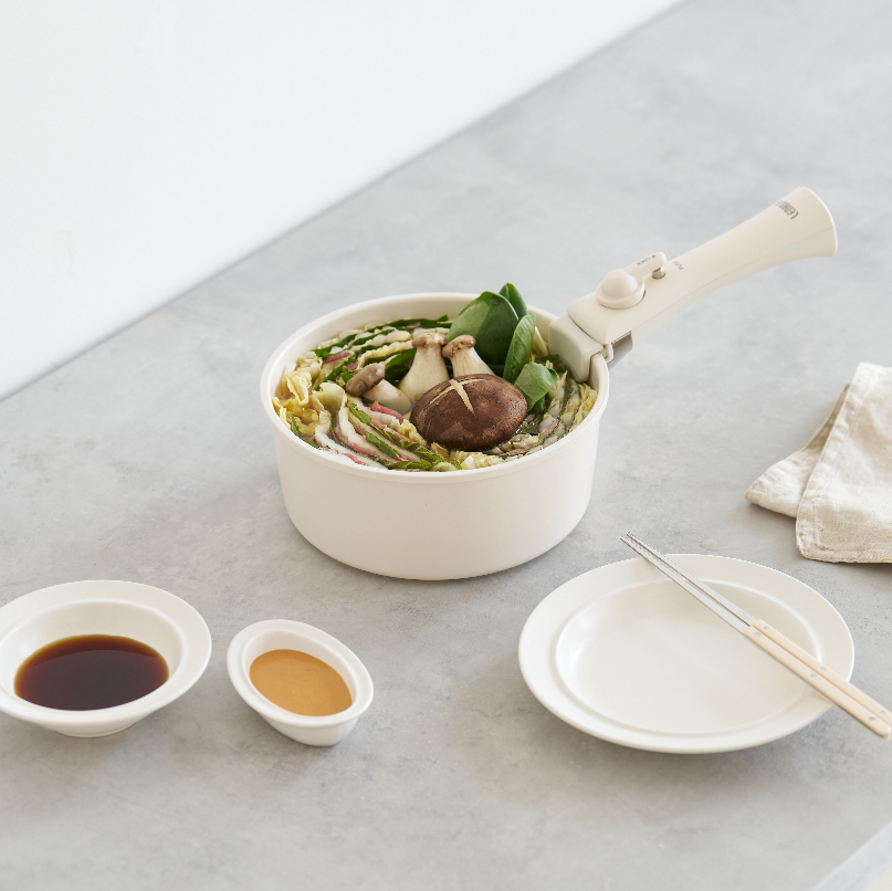 取手も本体も真っ白でお洒落な鍋で作った料理が食卓に並んでいる様子