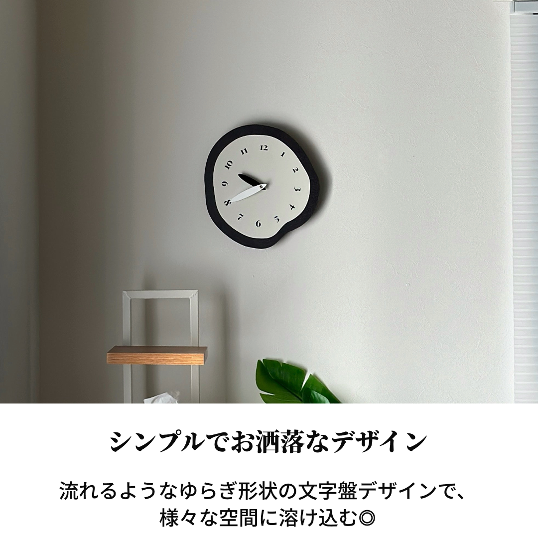 モノクロ掛け時計の黒い不規則なフレームと白い文字盤に太字の黒い数字があるミニマルな壁時計です。