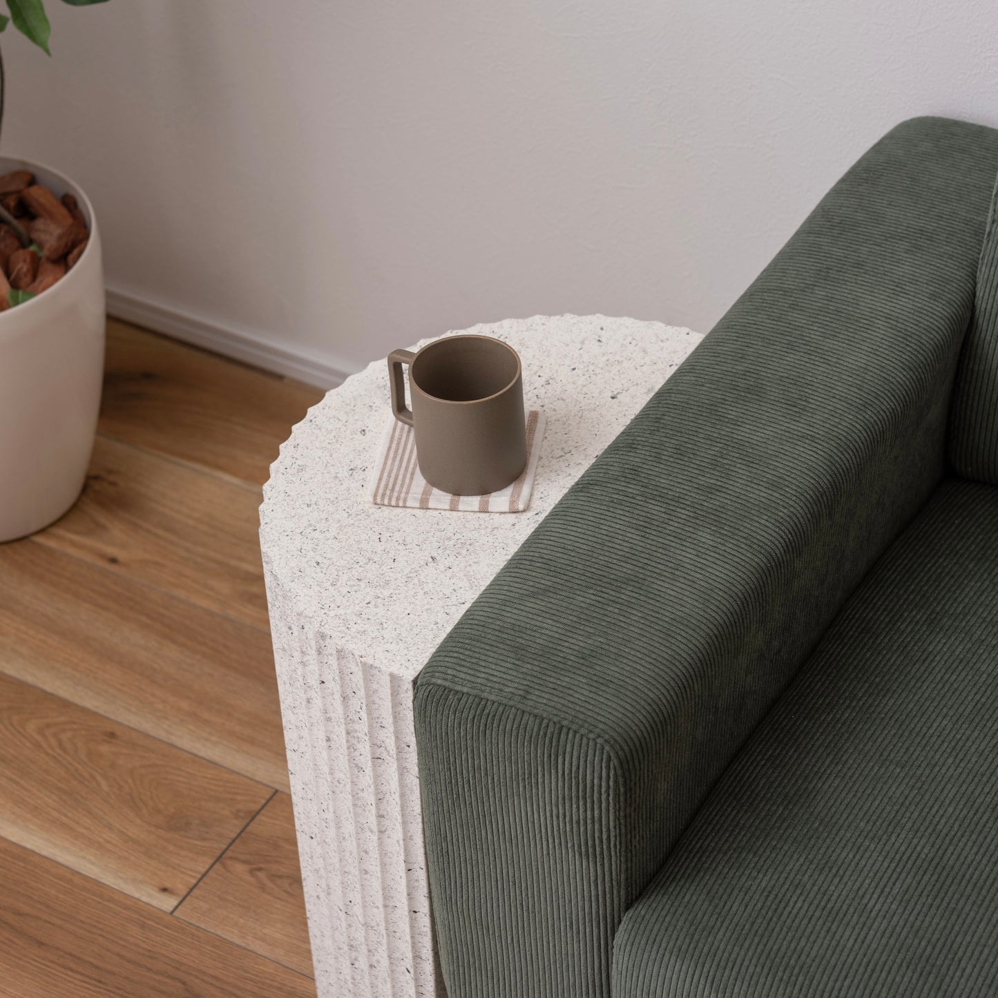 テラゾー柄の半円のスツールがソファサイドに置かれている様子