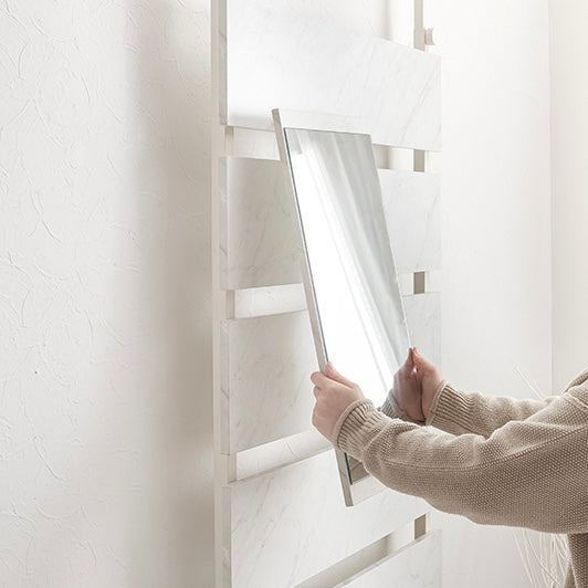 マーブルホワイトの突っ張りミラー付きラックに鏡を取り付けている様子