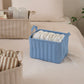 キルティング素材のブルーのバスケットにオムツが収納されている様子