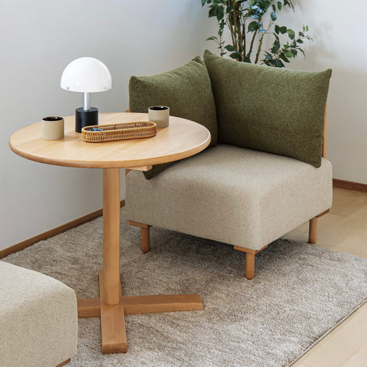 高さ調整可能なラウンドテーブルがソファの前に置かれている様子