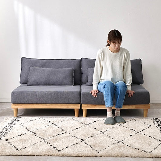 座面が広い2人掛けのソファに女性が座っている様子