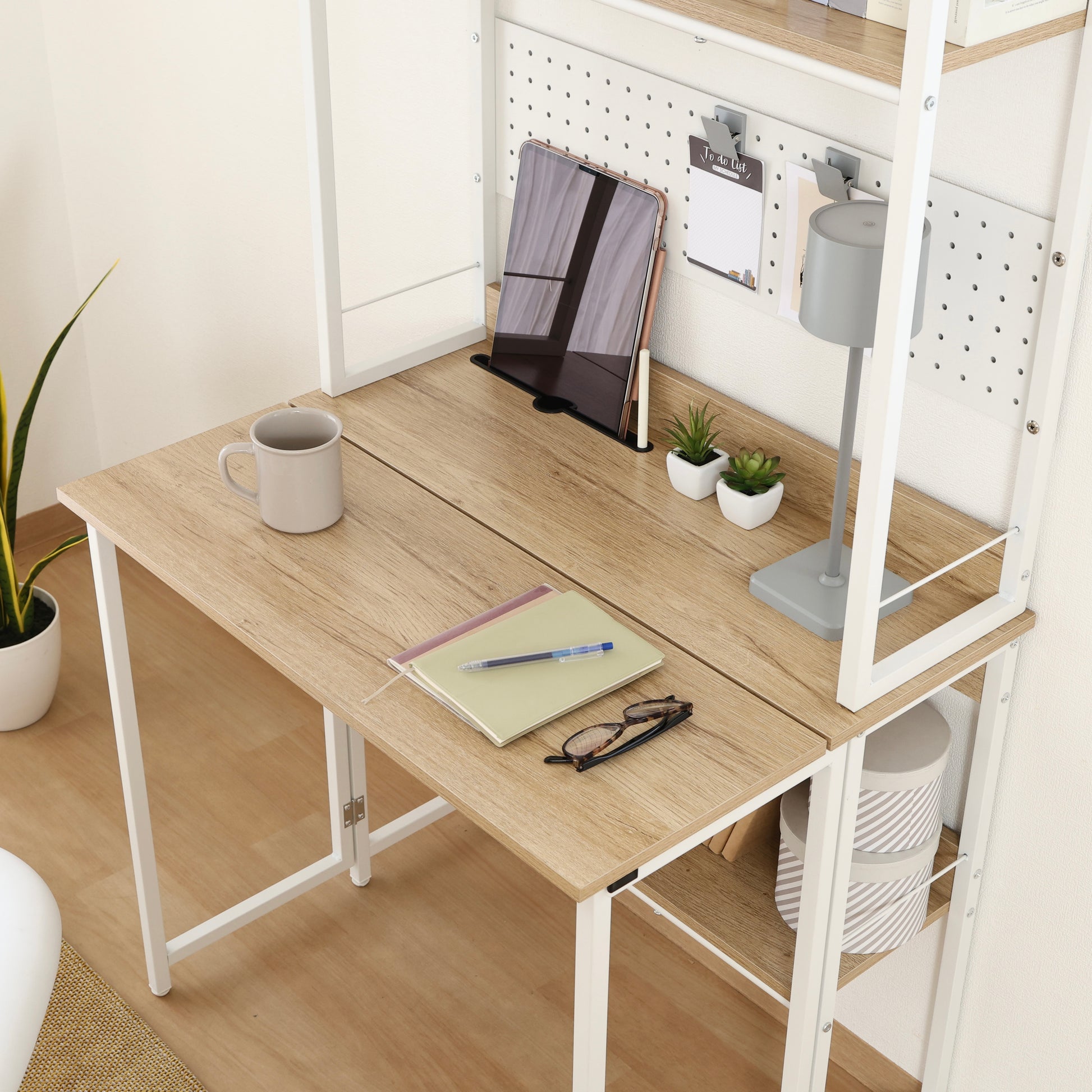 天板が折りたためる収納棚が付いたデスクに文房具が置かれている様子
