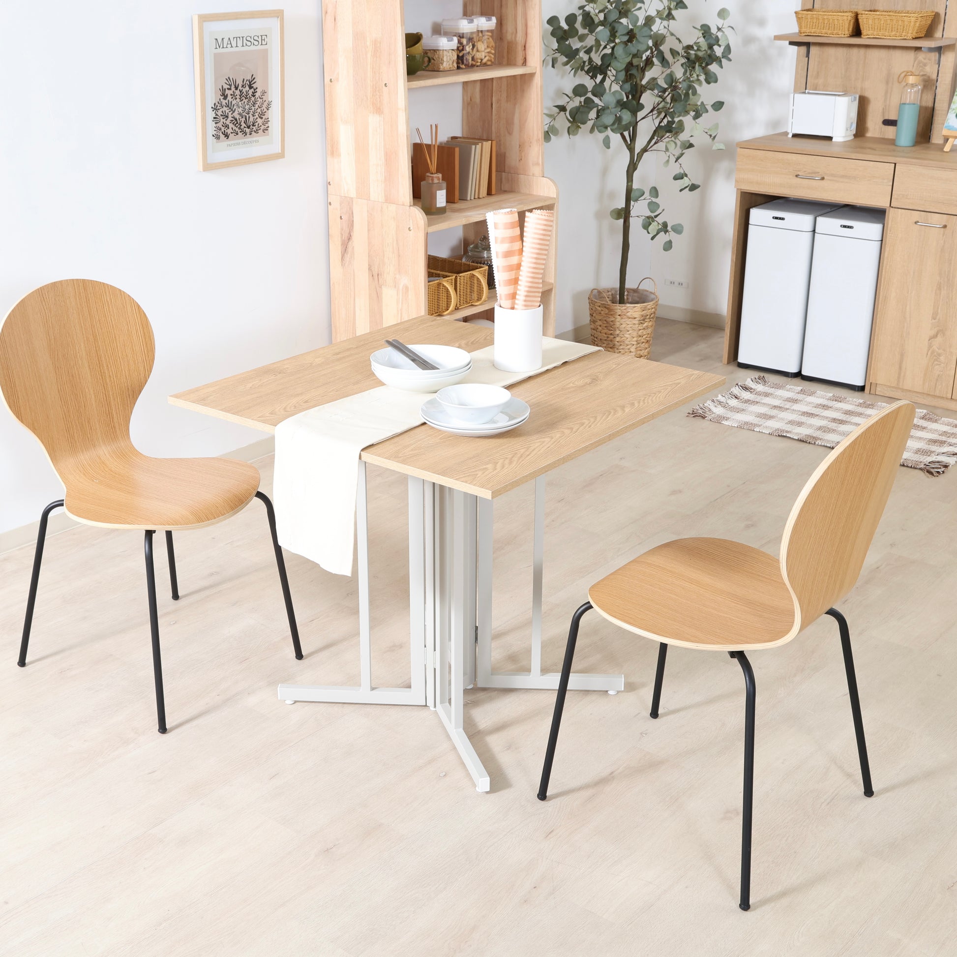 ウッド天板とスチール脚の異素材組み合わせの折りたたみ式のダイニングテーブルが置かれている様子