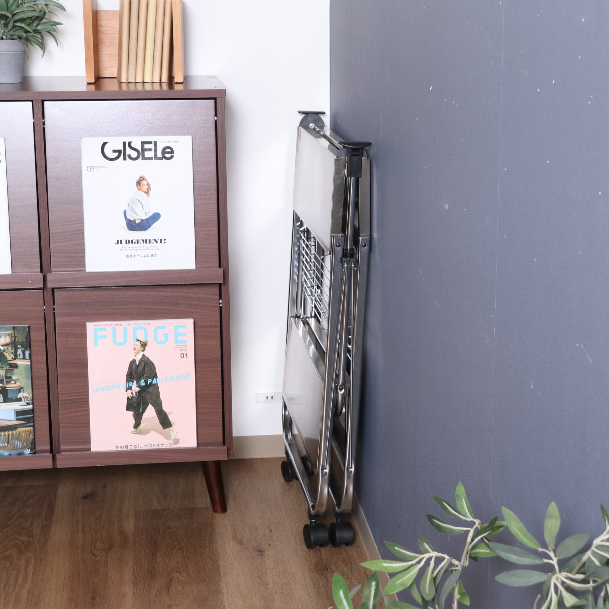 シルバーのフォールディングワゴンを折りたたんで壁に立てかけている様子