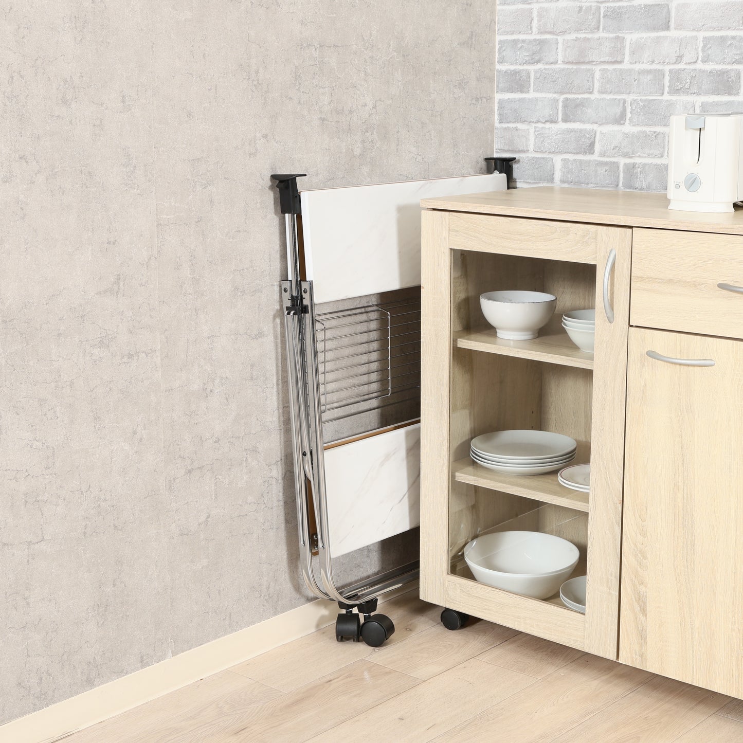 ホワイトのフォールディングワゴンを食器棚と壁の隙間に畳んで収納している様子