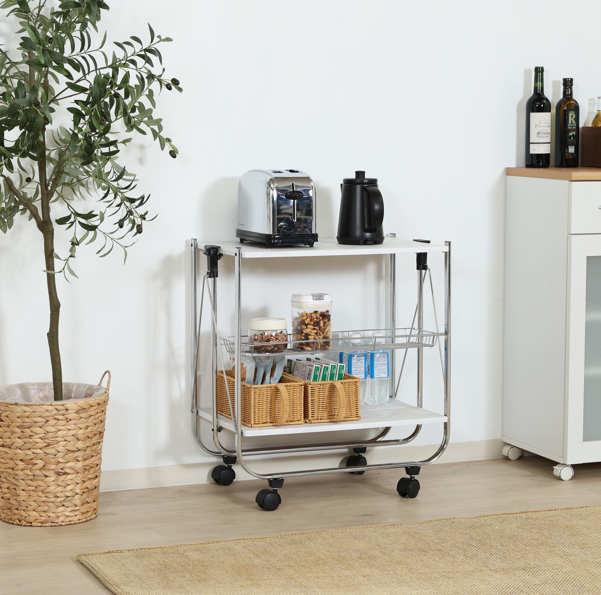 ホワイトのフォールディングワゴンにキッチングッズや食料品を置いている様子