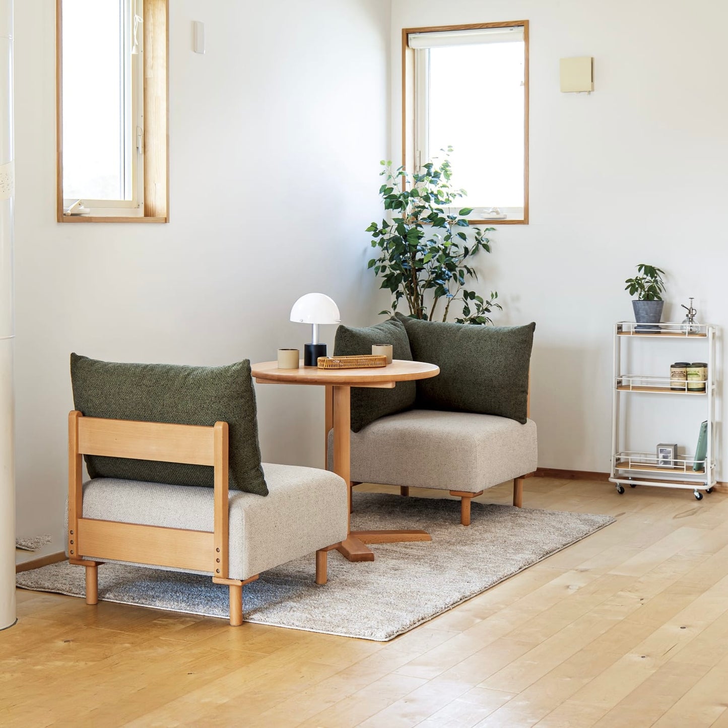 木製フレームのモスグリーンのソファがダイニングに置かれている様子