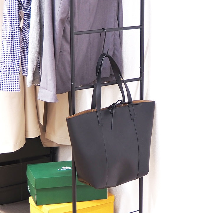 ブラウンの衣類を掛けるハンガーポールと7杯の引き出しを組み合わせた多機能なハンガーラックのサイドにS字フックでバッグをかけている様子