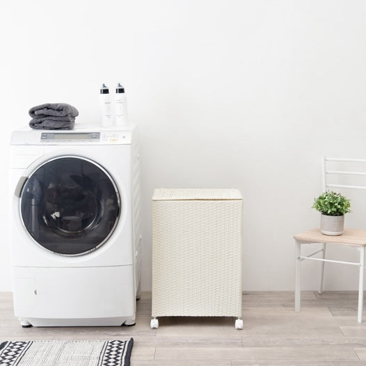 ホワイトのキャスター付ラタン調収納ボックスを洗濯機の横に置いている様子