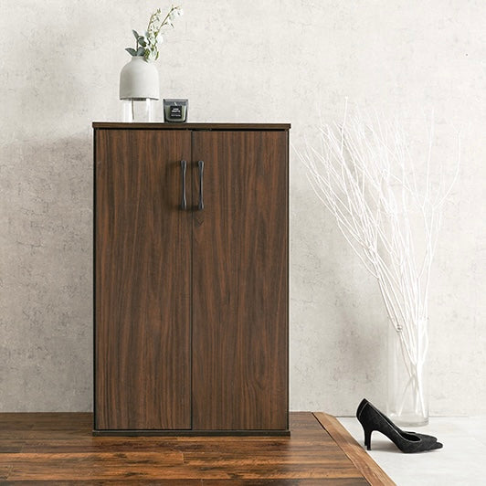 ブラウンカラーのシューズラックの上に雑貨が飾られている