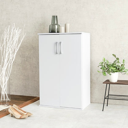 ホワイトのシューズラックの上に花瓶やキャンドルが飾られている