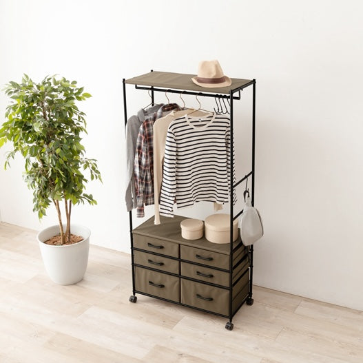 ファブリック素材の収納付きハンガーラックに洋服やばバッグが収納されている