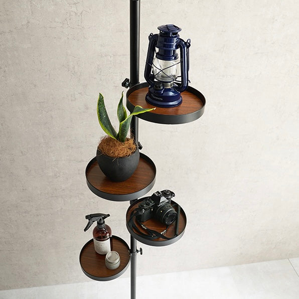 トレイ部分が丸型の突っ張りポールラックに植物やカメラが置かれている