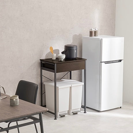 ダークブラウンのゴミ箱上収納の横に冷蔵庫が置かれている