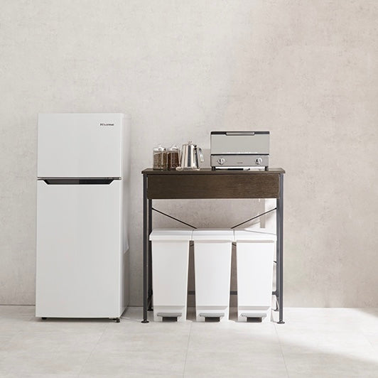 ダークブラウンのゴミ箱上収納の横に冷蔵庫が置かれている