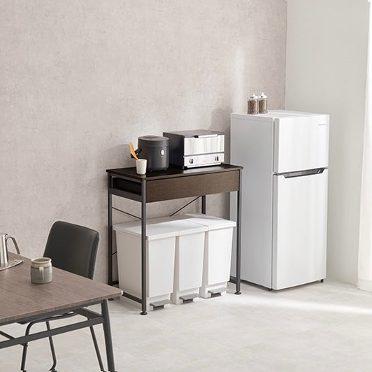 ダークブラウンのゴミ箱上収納の上に炊飯器が置かれていて横に冷蔵庫がある