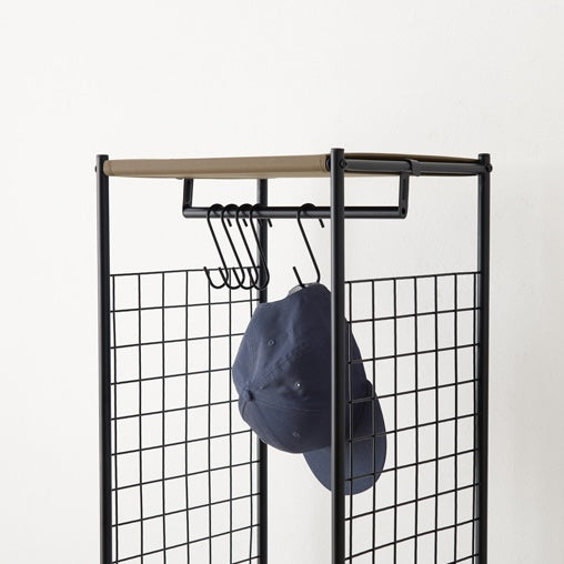 ブラウンのスリムなハンガーラックに帽子をかけている様子