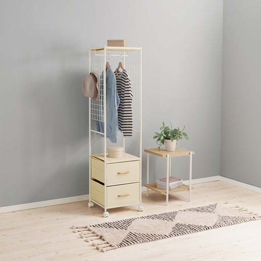 ホワイトのスリムなハンガーラックに洋服や帽子がかかっている様子