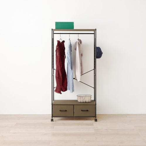 ブラウンのファブリック収納付きハンガーラックに洋服や帽子がかかっている様子