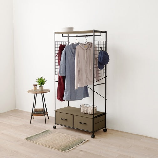 ブラウンのファブリック収納付きハンガーラックを部屋に置いている様子