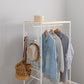 ホワイトのファブリック収納付きハンガーラックに洋服や帽子、バッグをかけている様子