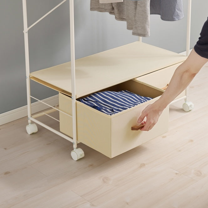 ホワイトのファブリック収納付きハンガーラックの収納部分を開けている様子