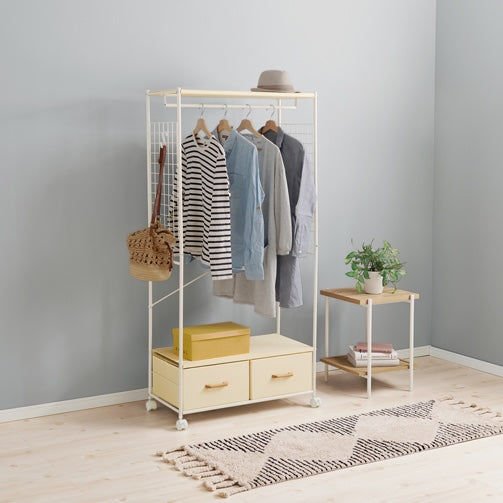 ホワイトのファブリック収納付きハンガーラックに洋服が4着かかっている様子